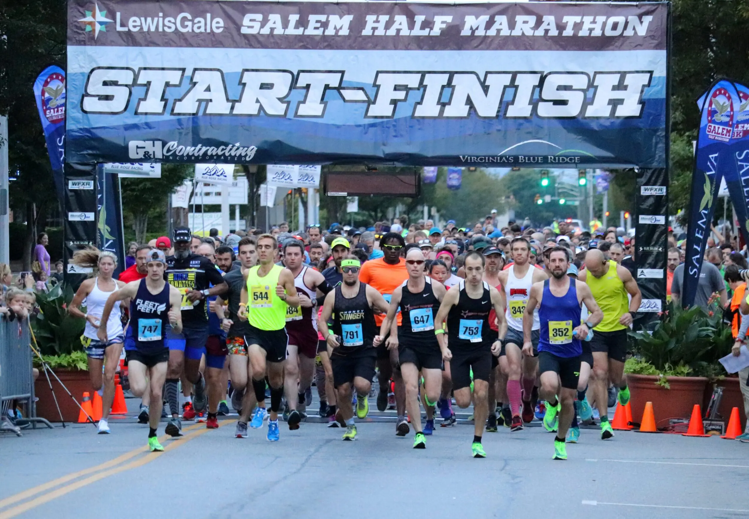 Crowd of runners taking off at the starting line for the annual Salem Half Marathon.