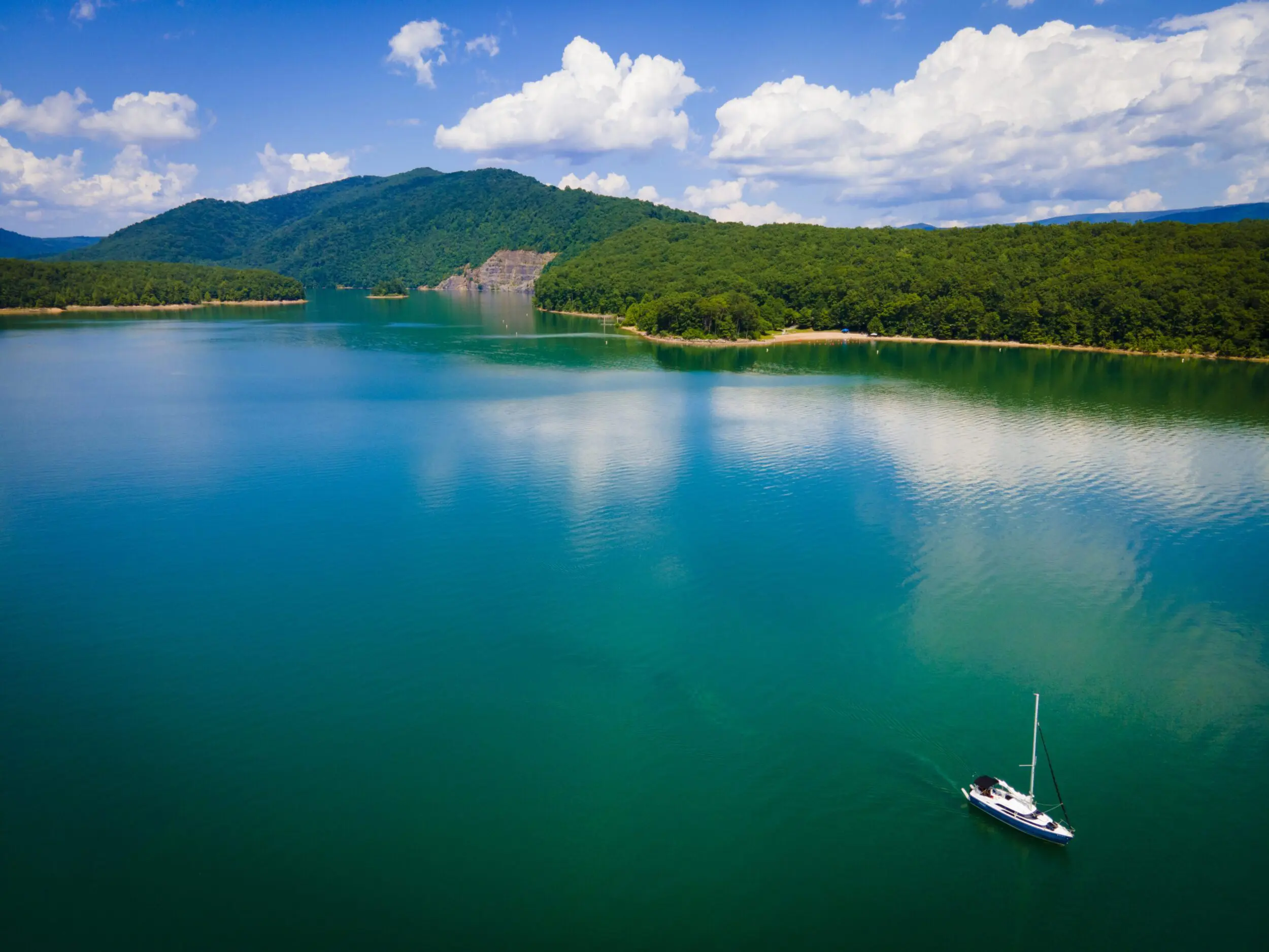 The beautiful teal waters of the Lake Moomaw surrounded by green mountains.