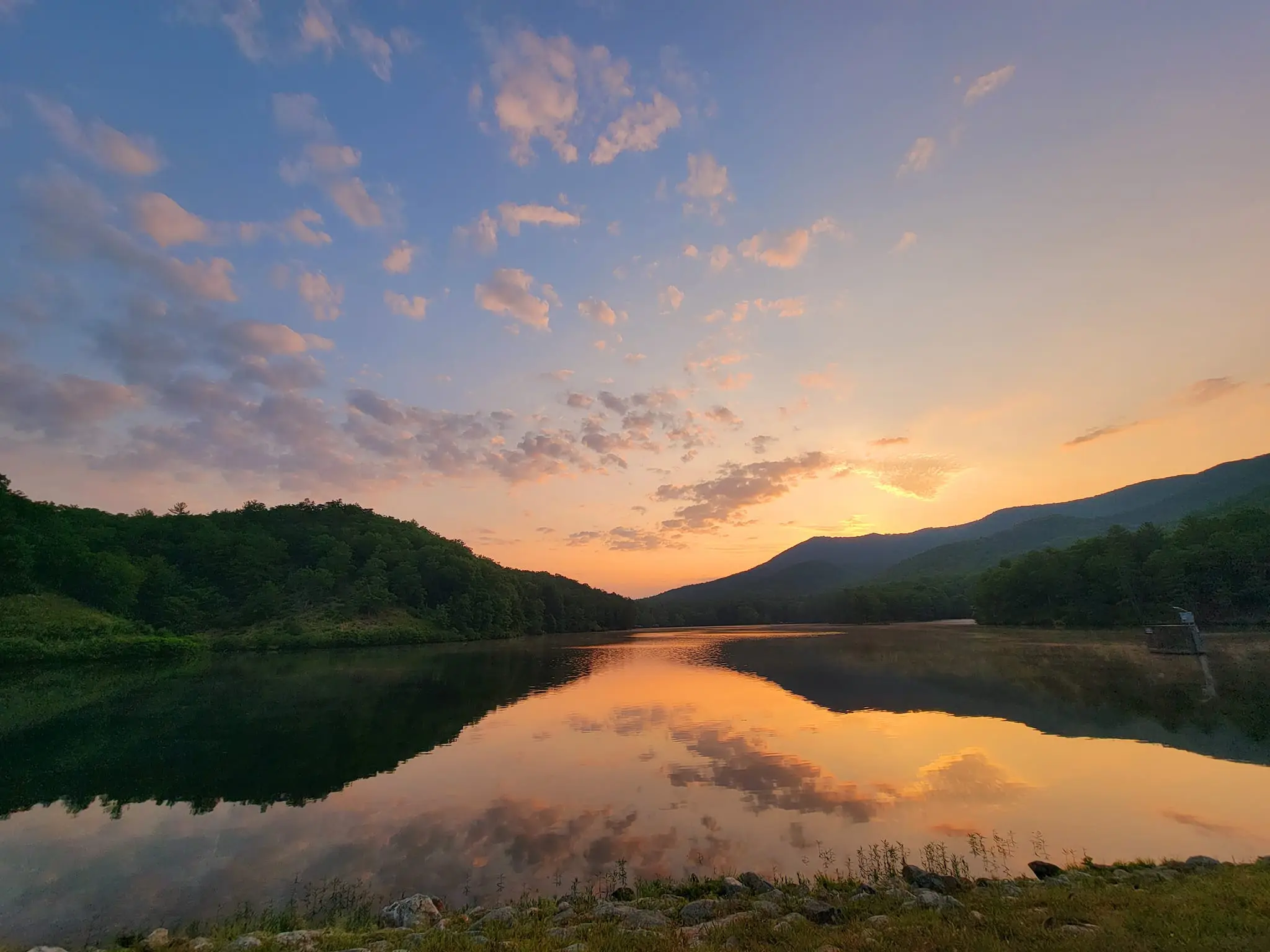 Beautiful sunset shot at a lake with mountains surrounding it.