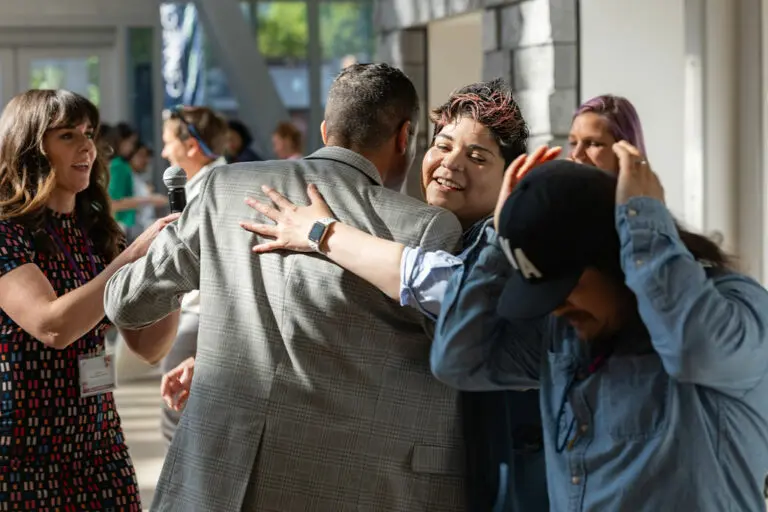 Virginia State Delegate Sam Rasoul hugs conference attendees.