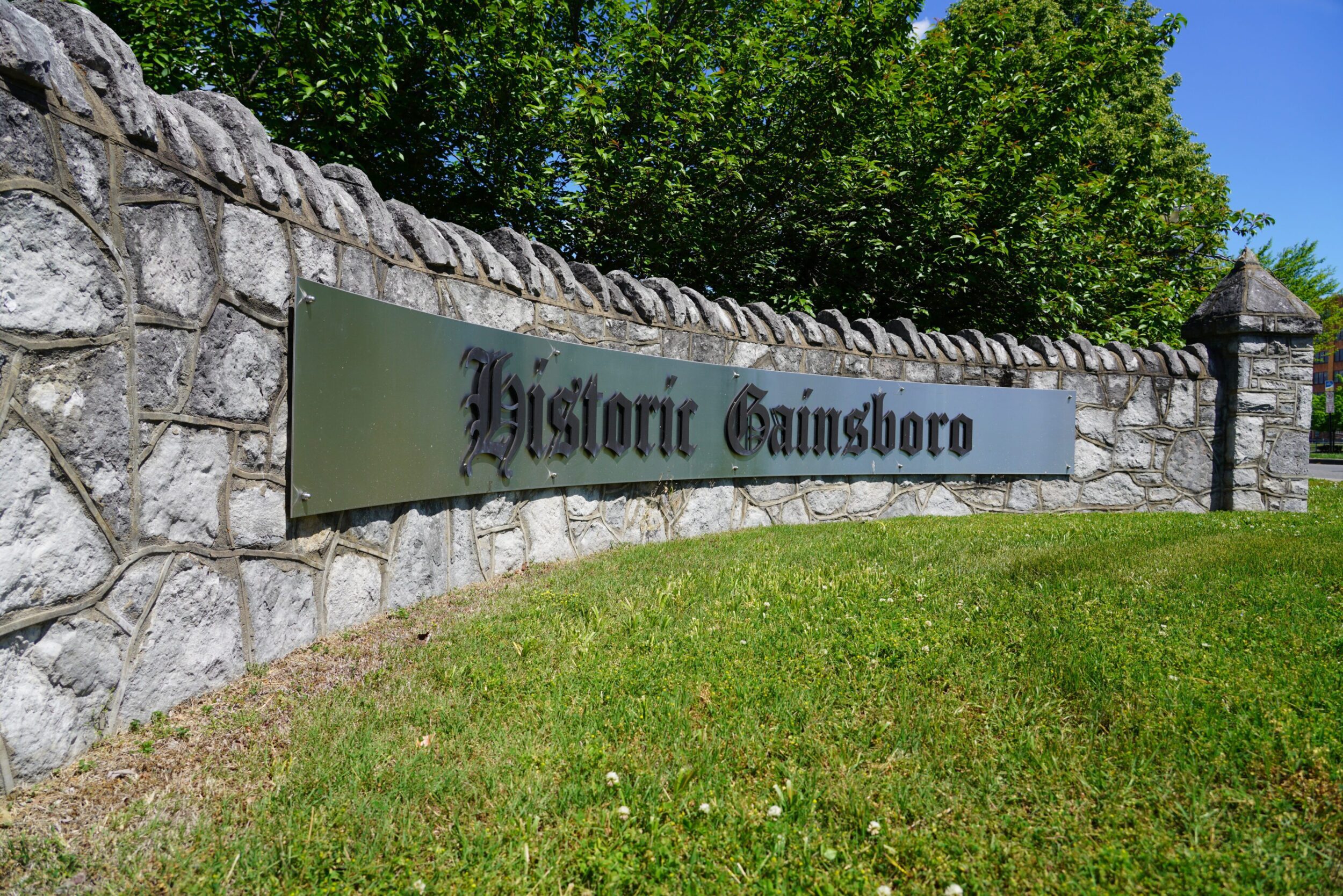 Stone wall with long metal sign that reads "Historic Gainsboro."