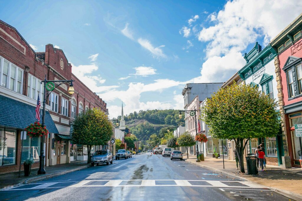 Downtown Covington, VA. The street is lined with historic store fronts and ends with a large mountain covered in green trees.