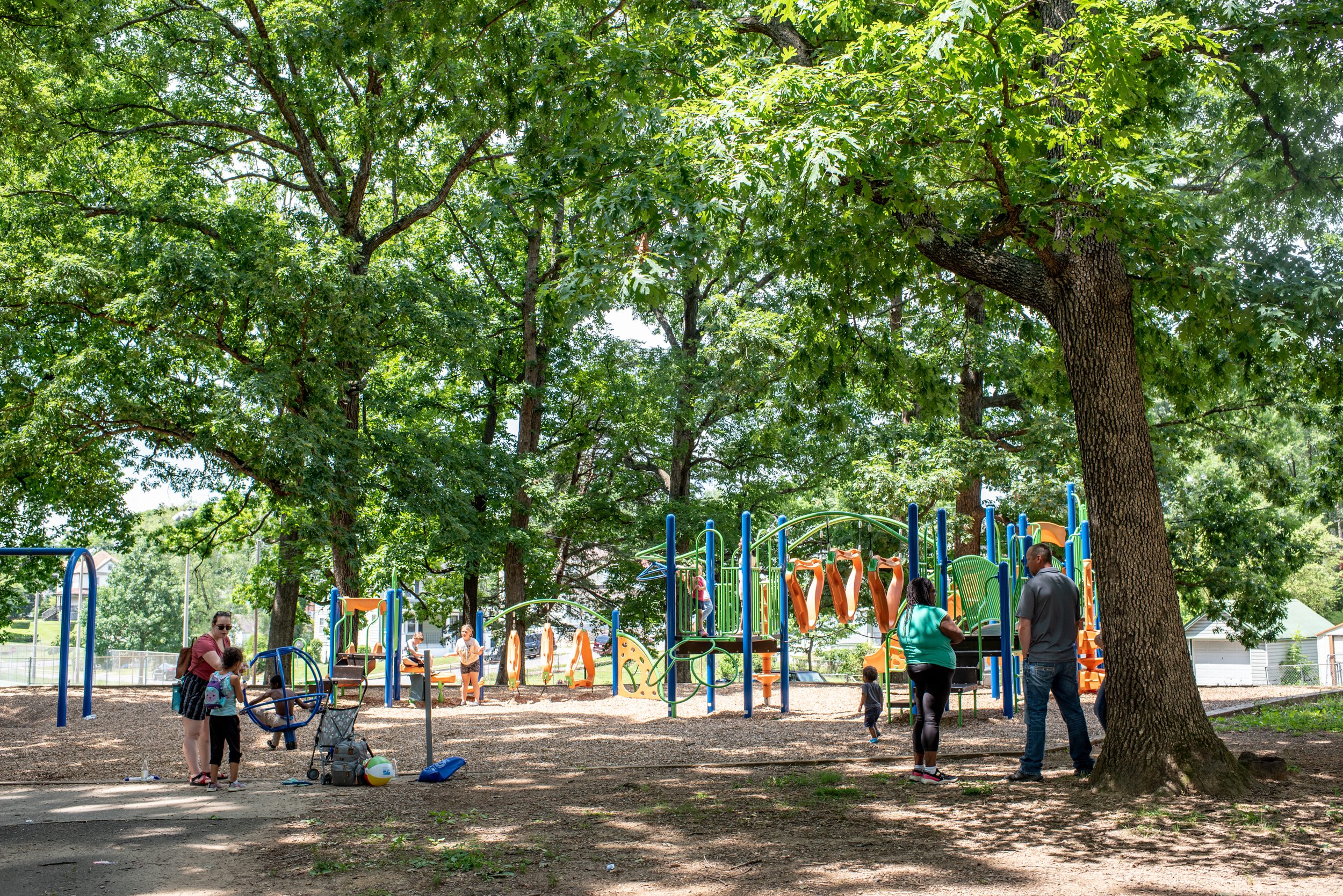 Families playing on a shaded playground in Roanoke, Virginia.