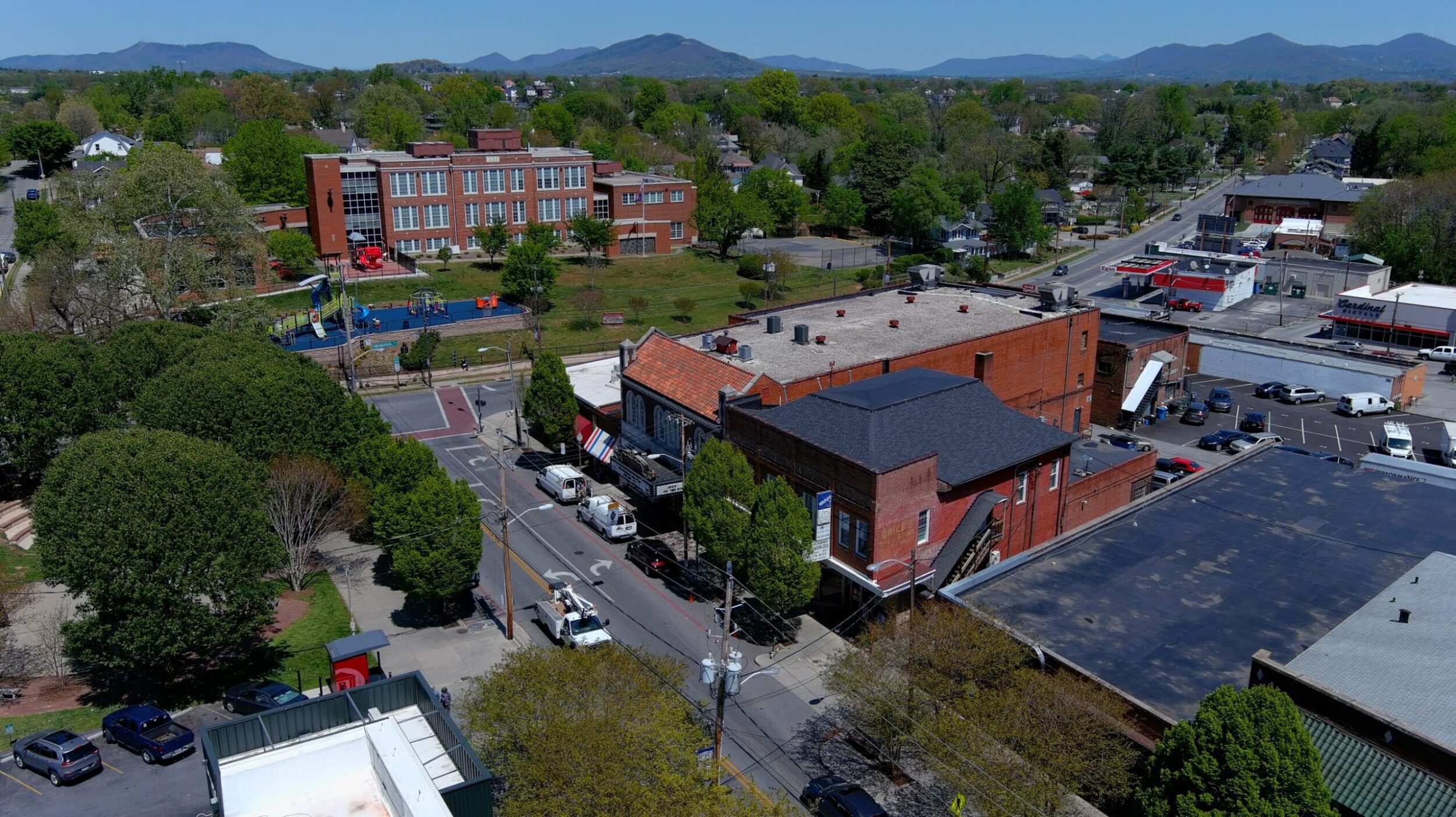 Overhead shot of the Grandin Village neighborhood in Roanoke, VA. It's a sunny, summer day with green trees and mountains in the background.