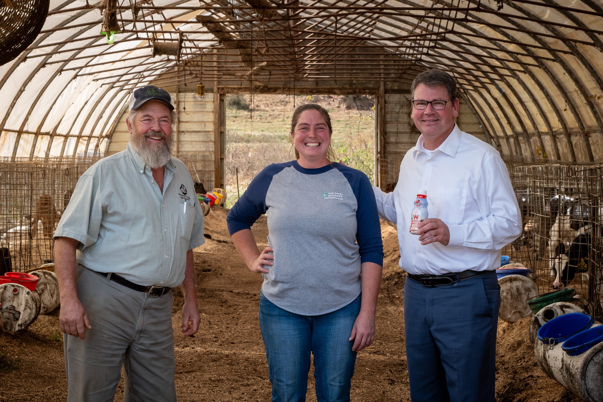 Three people from Bowmont Dairy (a white man with a beard, a woman, and a tall white man with glasses) pose and smile for the camera.