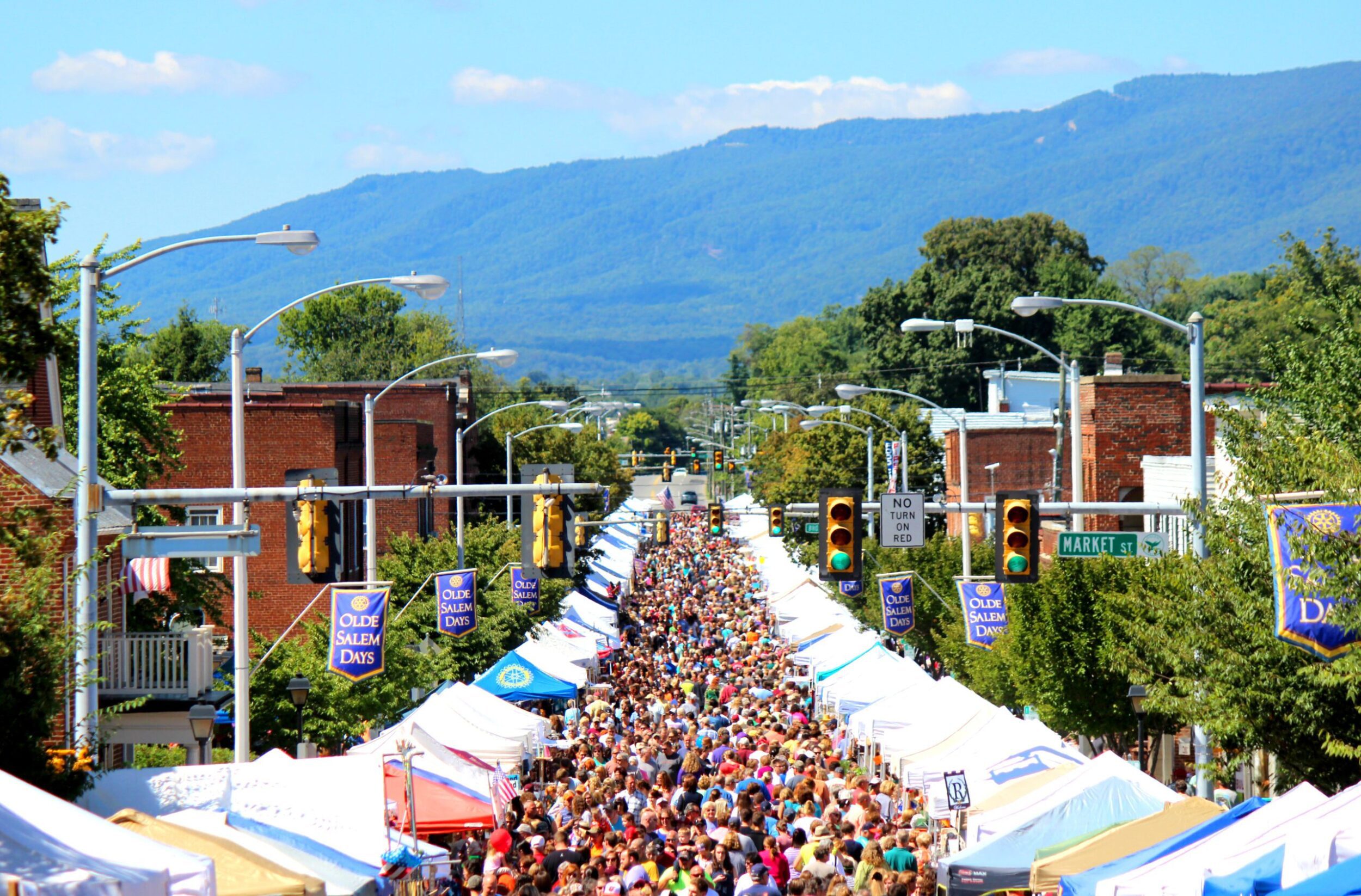 Main Street in Salem, VA, during Olde Salem Days. The street is lined with vendor tents and packed with people.