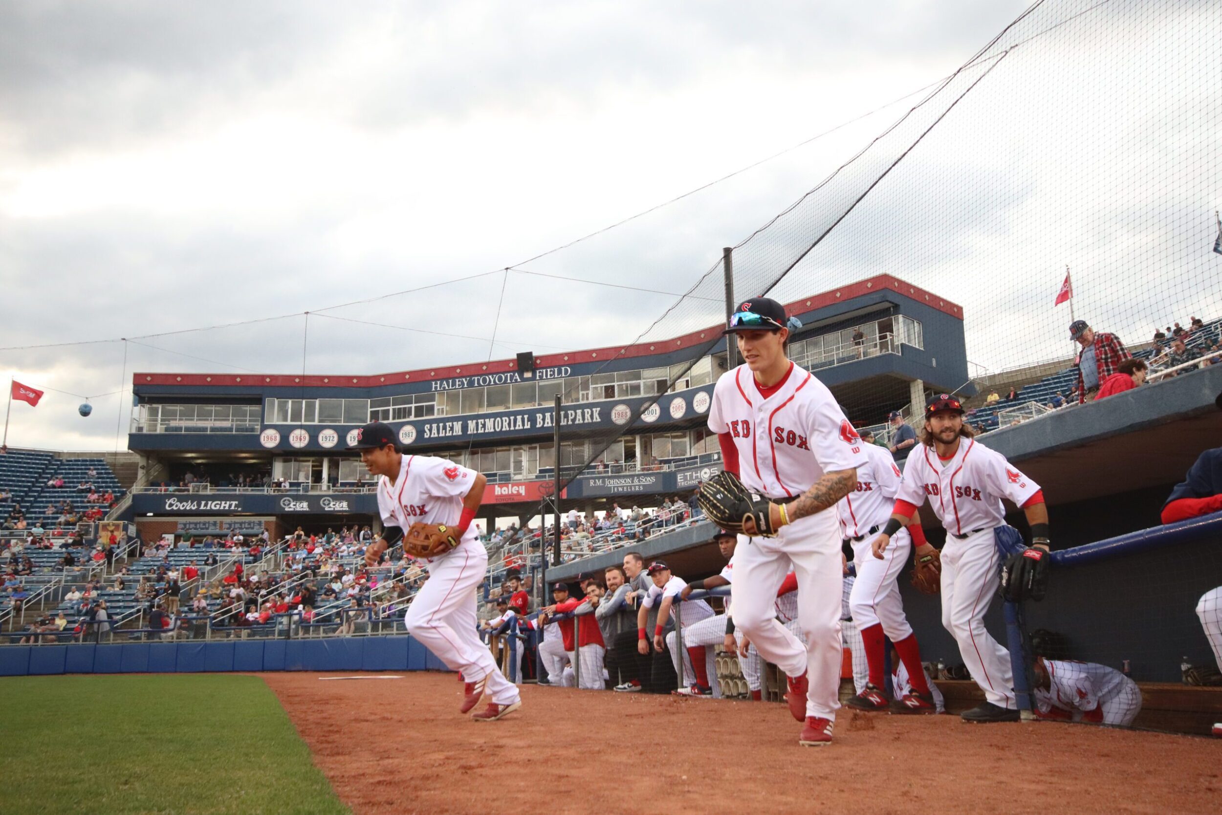 Players on the Salem Red Sox teams run out onto the field at Salem Memorial Baseball Ballpark at Carilion Clinic Field.