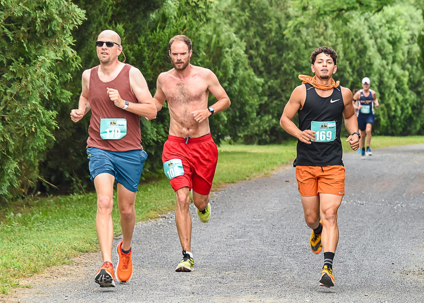 Three men wearing running clothes and racing bibs compete in marathon in Alleghany County, VA.