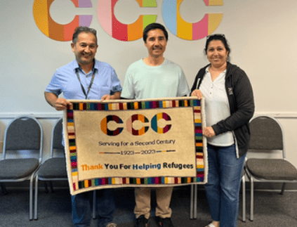 Three immigrants holding a banner